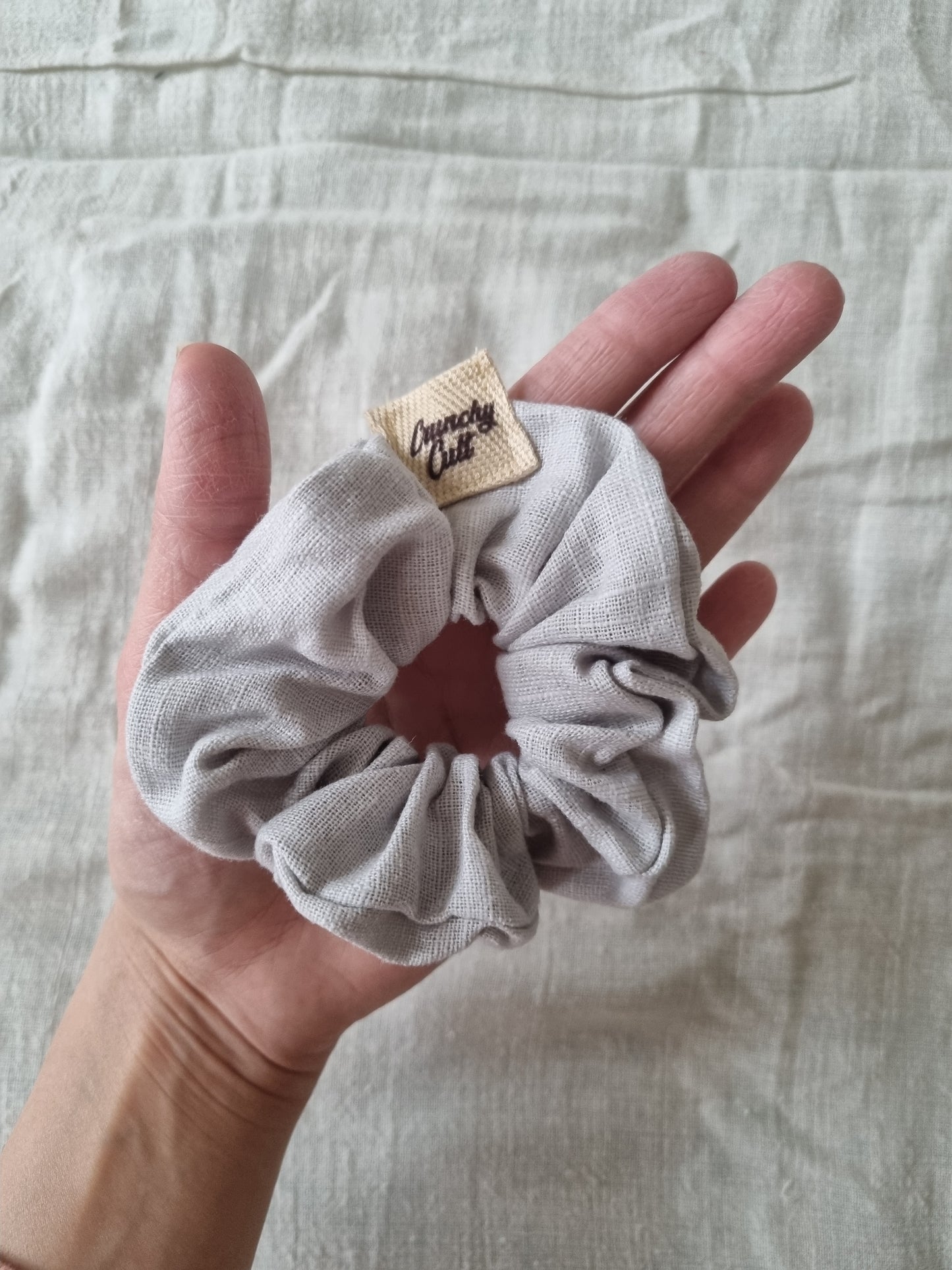 Grey hair scrunchie on palm of hand