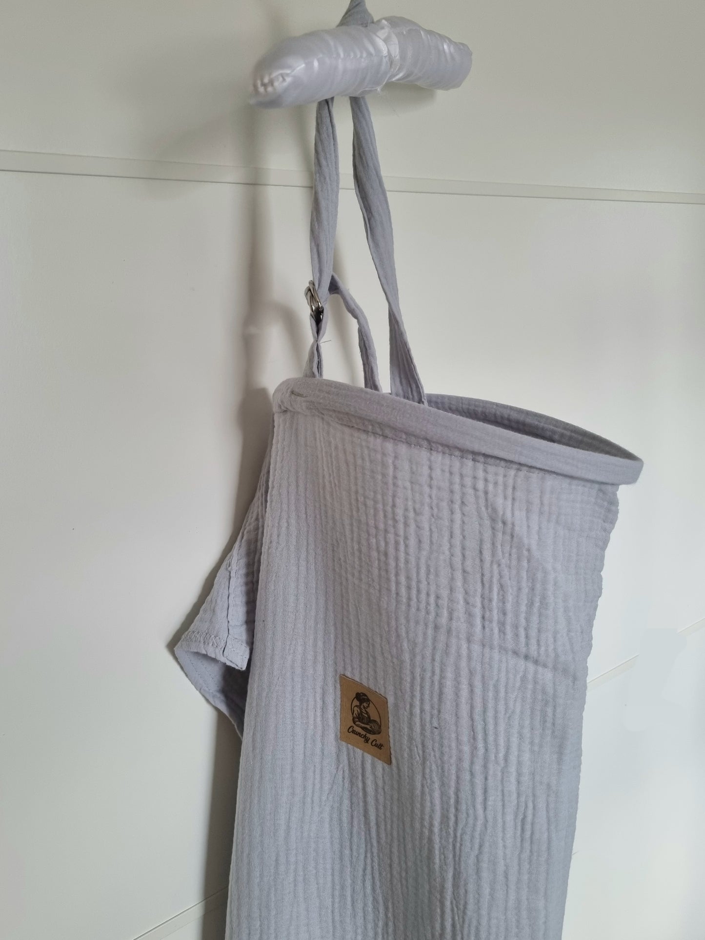 Grey breastfeeding cover, close-up view, showing the adjustable belt and logo