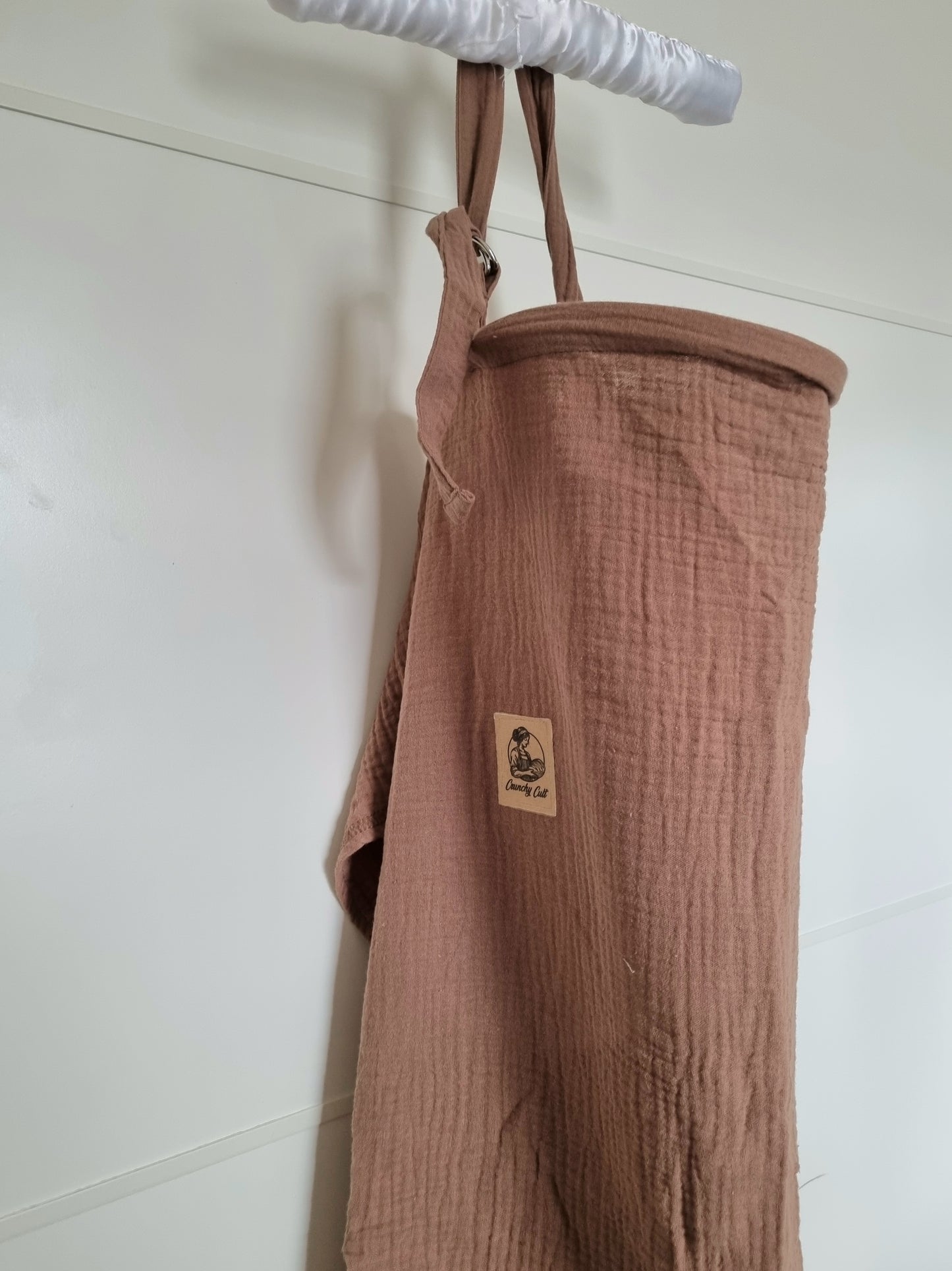 Brown breastfeeding cover, close-up view, showing the adjustable belt and logo