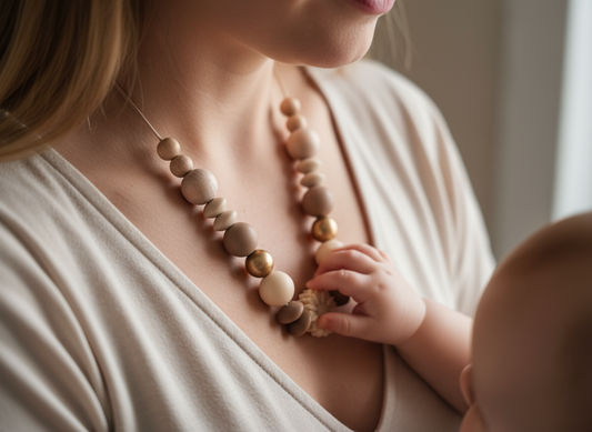 Baby playing with nursing necklace worn by mum