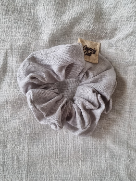 Grey linen hair scrunchy, single, top view, modelled on grey sheet