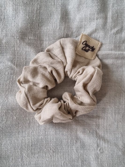 Baige linen hair scrunchy, single, top view, modelled on grey sheet