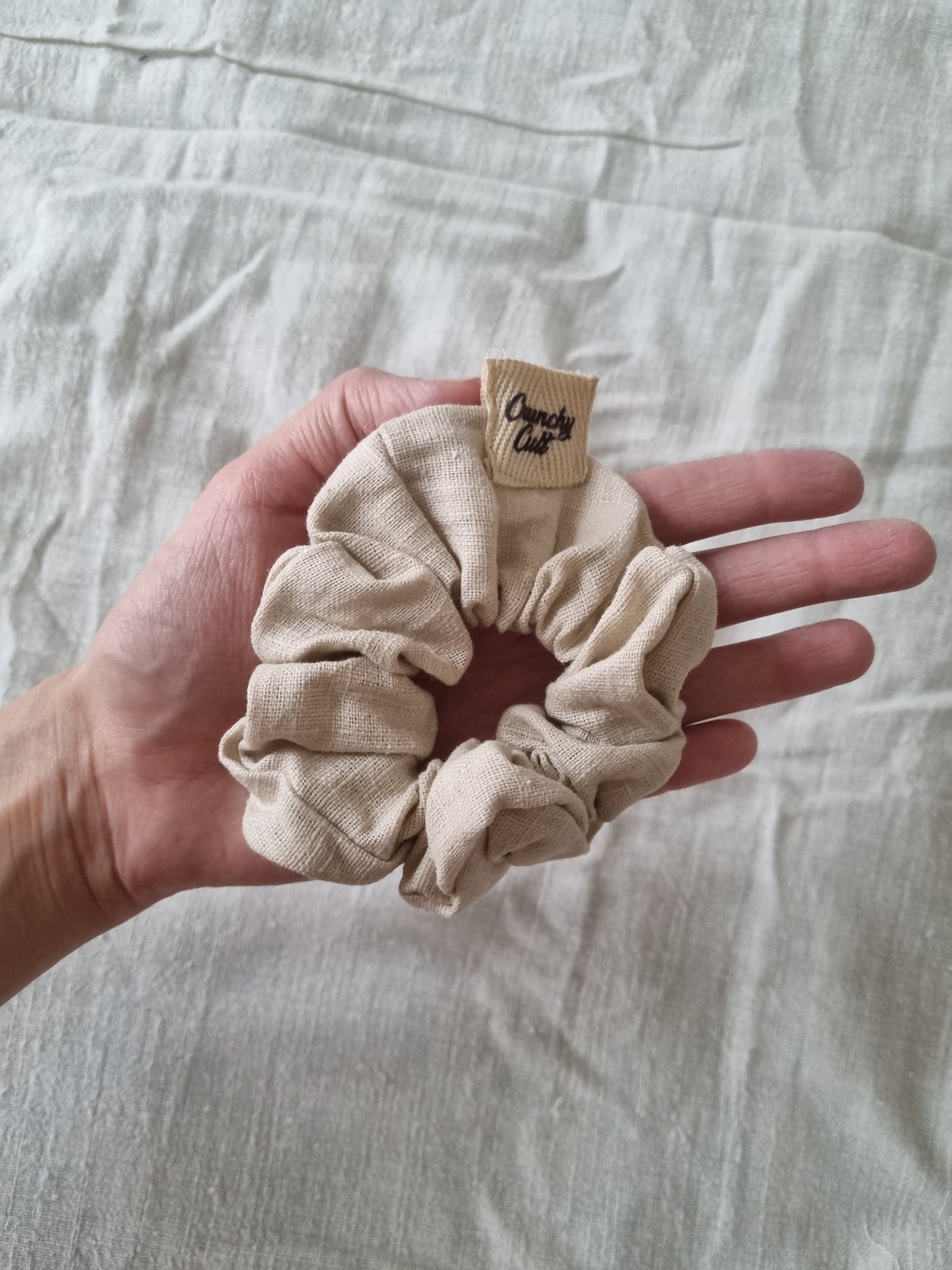 Baige hair scrunchie on palm of hand 
