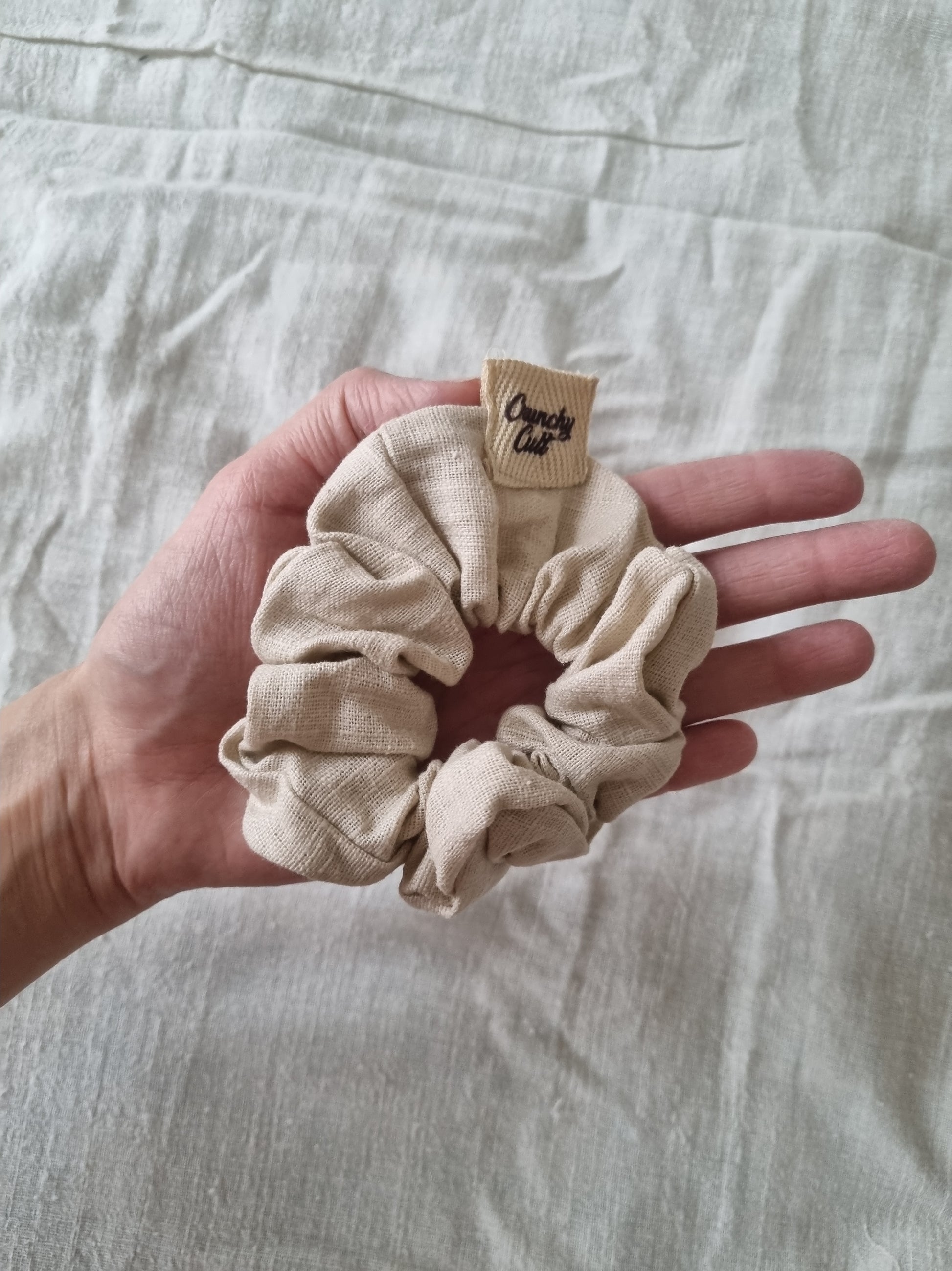 Baige hair scrunchie on palm of hand 