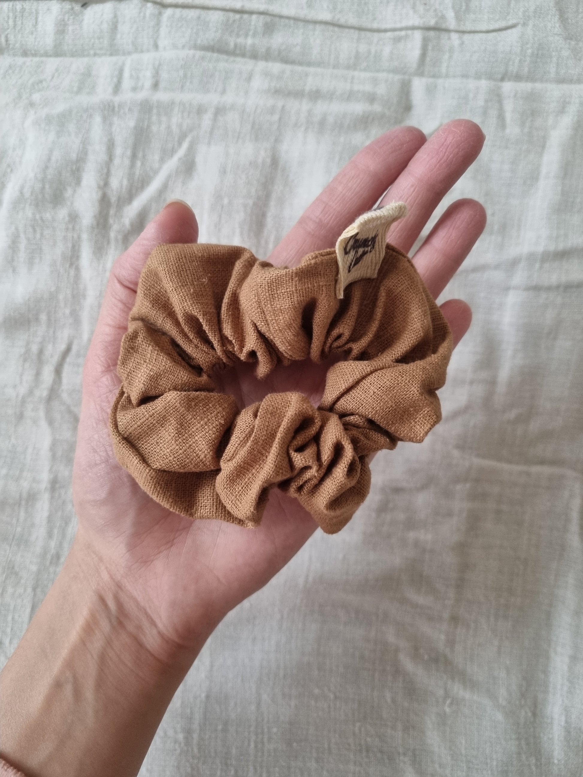 Brown hair scrunchie on palm of hand 